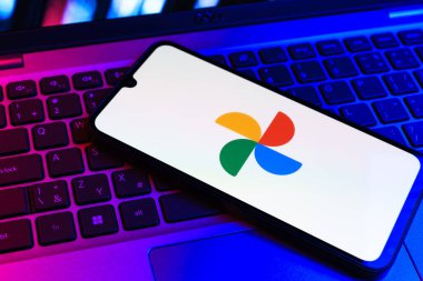 Prag, Çek Cumhuriyeti - 09 02 2025: Laptop klavyesindeki telefon renkli ışık göstergeleri Google Photos logosunu gösteriyor. Google Fotoğrafları fotoğraf ve videoları saklamak ve düzenlemek için bir platformdur.