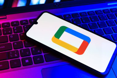 Prag, Çek Cumhuriyeti - 09 02 2025: Laptop klavyesindeki telefon renkli ışık gösterileri Google TV logosunu gösteriyor. Google TV film, program ve uygulamalar için bir platformdur..