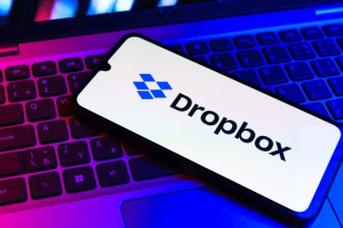 Prag, Çek Cumhuriyeti - 09 02 2025: Telefonun klavyesi renkli ışık gösteren Dropbox logosuyla aydınlatıldı. Dropbox bulut depolama ve dosya paylaşımı için bir platformdur.