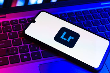 Prag, Çek Cumhuriyeti - 09 02 2025: Renkli ışık logosuyla aydınlatılan dizüstü bilgisayardaki telefon Lightroom logosunu gösteriyor. Lightroom fotoğraf düzenleme ve yönetim için bir yazılımdır..