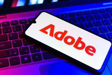 Prag, Çek Cumhuriyeti - 09 02 2025: Telefonun klavyesinde renkli ışık gösterileri Adobe logosu var. Adobe yaratıcı araçlar ve hizmetler sunan bir yazılım şirketidir..