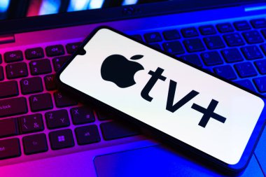 Prag, Çek Cumhuriyeti - 09 02 2025: Laptop klavyesindeki telefon renkli ışık gösterileri Apple TV + logosu. Apple TV +, filmler ve TV programları için bir yayın platformudur..