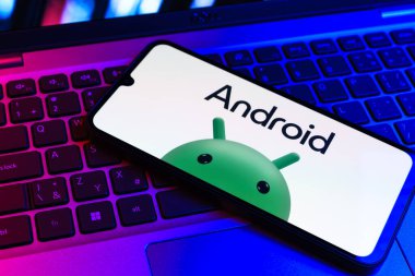 Prag, Çek Cumhuriyeti - 09 02 2025: Renkli ışık tarafından yakılan dizüstü bilgisayardaki telefon Android logosunu gösteriyor. Android akıllı telefonlar ve tabletler için mobil bir işletim sistemidir..
