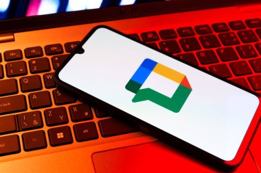 Prag, Çek Cumhuriyeti - 09 02 2025: Laptop klavyesindeki telefon renkli ışıklarla aydınlatılmış Google Chat logosunu gösteriyor. Google Chat mesajlaşma ve takım işbirliği için bir platformdur.