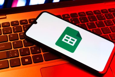 Prag, Çek Cumhuriyeti - 09 02 2025: Laptop klavyesindeki telefon renkli ışık göstergeleri Google Sheets logosunu gösteriyor. Google Sayfalar tablo oluşturmak ve yönetmek için bir platformdur.