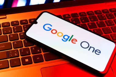 Prag, Çek Cumhuriyeti - 09 02 2025: Renkli ışık tarafından yakılan dizüstü bilgisayardaki telefon Google One logosunu gösteriyor. Google 1 bulut depolama ve abonelik hizmetleri için bir platformdur.