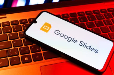 Prag, Çek Cumhuriyeti - 09 02 2025: Laptop klavyesindeki telefon renkli ışık göstergesi Google Slides logosunu gösteriyor. Google Slides sunumlar ve slayt gösterileri oluşturmak için bir platformdur.