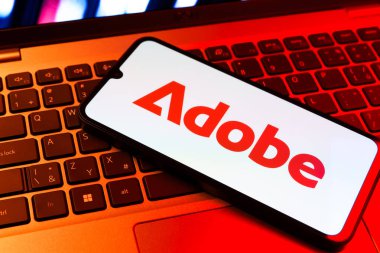 Prag, Çek Cumhuriyeti - 09 02 2025: Telefonun klavyesinde renkli ışık gösterileri Adobe logosu var. Adobe yaratıcı araçlar ve hizmetler sunan bir yazılım şirketidir..
