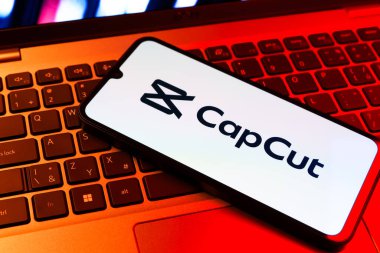Prag, Çek Cumhuriyeti - 09 02 2025: Laptop klavyesindeki telefon renkli ışık göstergeleri CapCut logosunu gösteriyor. CapCut video düzenleme ve oluşturma için bir platformdur.