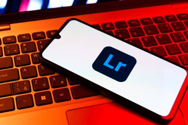 Prag, Çek Cumhuriyeti - 09 02 2025: Renkli ışık logosuyla aydınlatılan dizüstü bilgisayardaki telefon Lightroom logosunu gösteriyor. Lightroom fotoğraf düzenleme ve yönetim için bir yazılımdır..