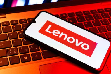 Prag, Çek Cumhuriyeti - 09 02 2025: Renkli ışıklarla aydınlatılmış dizüstü bilgisayardaki telefon Lenovo logosunu gösteriyor. Lenovo bilgisayar ve elektronik üreten bir teknoloji şirketidir..