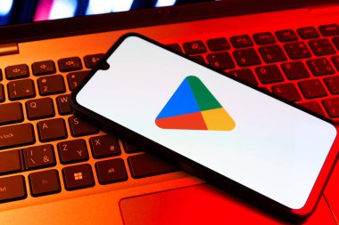 Prag, Çek Cumhuriyeti - 09 02 2025: Google Play logosunun renkli ışıklarla aydınlatıldığı dizüstü bilgisayardaki telefon. Google Play uygulamaları, oyunları ve dijital içeriği indirmek için bir platformdur.
