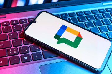 Prag, Çek Cumhuriyeti - 09 02 2025: Laptop klavyesindeki telefon renkli ışıklarla aydınlatılmış Google Chat logosunu gösteriyor. Google Chat mesajlaşma ve takım işbirliği için bir platformdur.