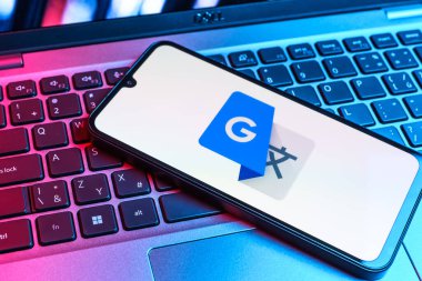 Prag, Çek Cumhuriyeti - 09 02 2025: Laptop klavyesindeki telefon renkli ışık göstergesi Google Translate logosunu gösteriyor. Google Çevirisi metni ve konuşmayı diller arası çevirmek için bir platformdur..