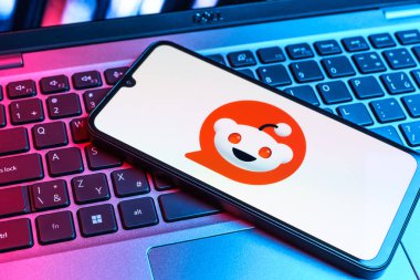 Prag, Çek Cumhuriyeti - 09 02 2025: Renkli ışık tarafından yakılan dizüstü bilgisayardaki telefon Reddit logosunu gösteriyor. Reddit tartışma, haber ve toplum içeriği için bir platformdur.