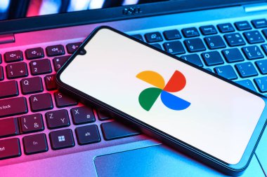 Prag, Çek Cumhuriyeti - 09 02 2025: Laptop klavyesindeki telefon renkli ışık göstergeleri Google Photos logosunu gösteriyor. Google Fotoğrafları fotoğraf ve videoları saklamak ve düzenlemek için bir platformdur.