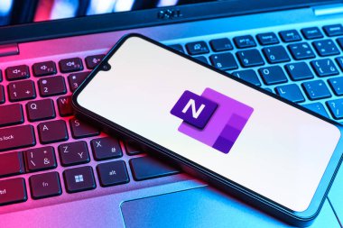 Prag, Çek Cumhuriyeti - 09 02 2025: Laptop klavyesindeki telefon Microsoft OneNote logosunu gösteriyor. Microsoft OneNote not almak ve düzenlemek için bir platformdur.