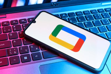Prag, Çek Cumhuriyeti - 09 02 2025: Laptop klavyesindeki telefon renkli ışık gösterileri Google TV logosunu gösteriyor. Google TV film, program ve uygulamalar için bir platformdur..
