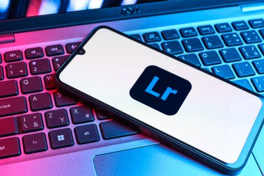 Prag, Çek Cumhuriyeti - 09 02 2025: Renkli ışık logosuyla aydınlatılan dizüstü bilgisayardaki telefon Lightroom logosunu gösteriyor. Lightroom fotoğraf düzenleme ve yönetim için bir yazılımdır..