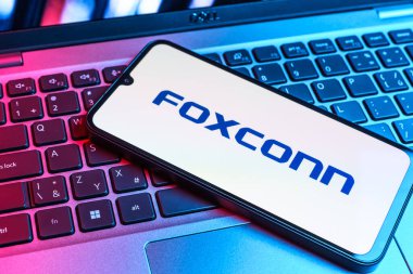 Prag, Çek Cumhuriyeti - 09 02 2025: Telefon dizüstü bilgisayarda renkli ışık tarafından aydınlatılmış Foxconn logosu. Foxconn elektronik ve parça üreten bir şirket..