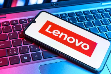 Prag, Çek Cumhuriyeti - 09 02 2025: Renkli ışıklarla aydınlatılmış dizüstü bilgisayardaki telefon Lenovo logosunu gösteriyor. Lenovo bilgisayar ve elektronik üreten bir teknoloji şirketidir..