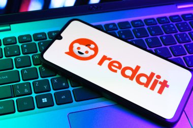 Prag, Çek Cumhuriyeti - 09 02 2025: Renkli ışık tarafından yakılan dizüstü bilgisayardaki telefon Reddit logosunu gösteriyor. Reddit tartışma, haber ve toplum içeriği için bir platformdur.