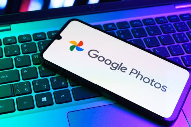 Prag, Çek Cumhuriyeti - 09 02 2025: Laptop klavyesindeki telefon renkli ışık göstergeleri Google Photos logosunu gösteriyor. Google Fotoğrafları fotoğraf ve videoları saklamak ve düzenlemek için bir platformdur.