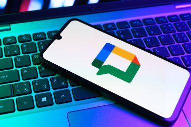 Prag, Çek Cumhuriyeti - 09 02 2025: Laptop klavyesindeki telefon renkli ışıklarla aydınlatılmış Google Chat logosunu gösteriyor. Google Chat mesajlaşma ve takım işbirliği için bir platformdur.