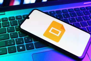 Prag, Çek Cumhuriyeti - 09 02 2025: Laptop klavyesindeki telefon renkli ışık göstergesi Google Slides logosunu gösteriyor. Google Slides sunumlar ve slayt gösterileri oluşturmak için bir platformdur.