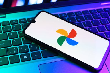 Prag, Çek Cumhuriyeti - 09 02 2025: Laptop klavyesindeki telefon renkli ışık göstergeleri Google Photos logosunu gösteriyor. Google Fotoğrafları fotoğraf ve videoları saklamak ve düzenlemek için bir platformdur.