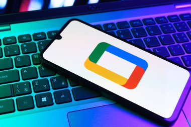 Prag, Çek Cumhuriyeti - 09 02 2025: Laptop klavyesindeki telefon renkli ışık gösterileri Google TV logosunu gösteriyor. Google TV film, program ve uygulamalar için bir platformdur..