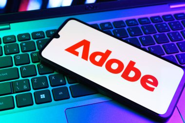 Prag, Çek Cumhuriyeti - 09 02 2025: Telefonun klavyesinde renkli ışık gösterileri Adobe logosu var. Adobe yaratıcı araçlar ve hizmetler sunan bir yazılım şirketidir..