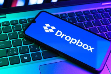 Prag, Çek Cumhuriyeti - 09 02 2025: Telefonun klavyesi renkli ışık gösteren Dropbox logosuyla aydınlatıldı. Dropbox bulut depolama ve dosya paylaşımı için bir platformdur.