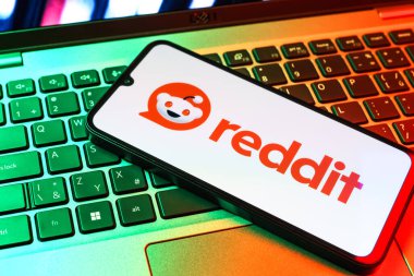 Prag, Çek Cumhuriyeti - 09 02 2025: Renkli ışık tarafından yakılan dizüstü bilgisayardaki telefon Reddit logosunu gösteriyor. Reddit tartışma, haber ve toplum içeriği için bir platformdur.