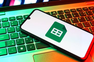 Prag, Çek Cumhuriyeti - 09 02 2025: Laptop klavyesindeki telefon renkli ışık göstergeleri Google Sheets logosunu gösteriyor. Google Sayfalar tablo oluşturmak ve yönetmek için bir platformdur.