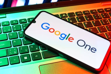 Prag, Çek Cumhuriyeti - 09 02 2025: Renkli ışık tarafından yakılan dizüstü bilgisayardaki telefon Google One logosunu gösteriyor. Google 1 bulut depolama ve abonelik hizmetleri için bir platformdur.