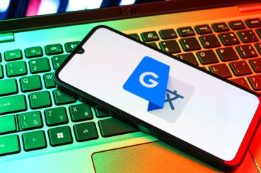 Prag, Çek Cumhuriyeti - 09 02 2025: Laptop klavyesindeki telefon renkli ışık göstergesi Google Translate logosunu gösteriyor. Google Çevirisi metni ve konuşmayı diller arası çevirmek için bir platformdur..