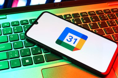Prag, Çek Cumhuriyeti - 09 02 2025: Laptop klavyesindeki telefon renkli ışıkla aydınlatılmış Google Takvim logosunu gösteriyor. Google Takvimi olayları zamanlamak ve yönetmek için bir platformdur.
