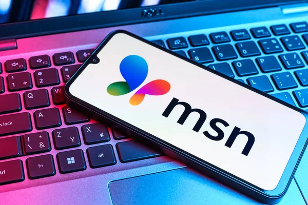 Prag, Çek Cumhuriyeti - 09 02 2025: MSN logosu renkli ışık tarafından yakılan dizüstü bilgisayardaki telefon. MSN haber, e-posta ve çevrimiçi hizmetler için bir platformdur.
