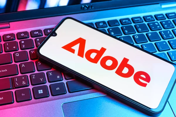 Prag, Çek Cumhuriyeti - 09 02 2025: Telefonun klavyesinde renkli ışık gösterileri Adobe logosu var. Adobe yaratıcı araçlar ve hizmetler sunan bir yazılım şirketidir..
