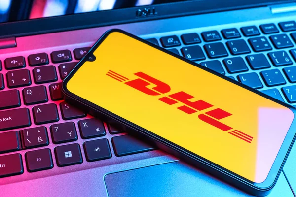 Prag, Çek Cumhuriyeti - 09 02 2025: DHL logosu renkli ışık tarafından yakılan dizüstü bilgisayardaki telefon. DHL uluslararası nakliye hizmeti sunan bir lojistik şirketidir..