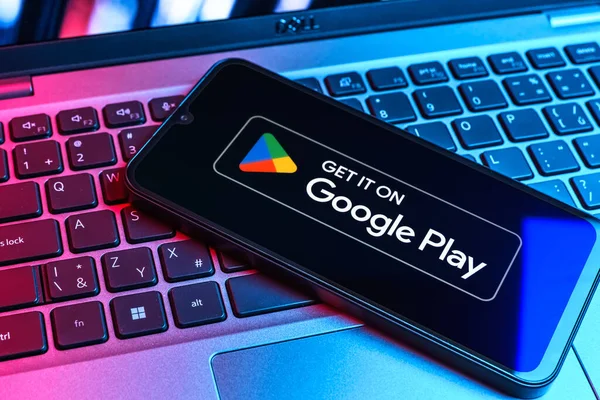Prag, Çek Cumhuriyeti - 09 02 2025: Google Play logosunun renkli ışıklarla aydınlatıldığı dizüstü bilgisayardaki telefon. Google Play uygulamaları, oyunları ve dijital içeriği indirmek için bir platformdur.