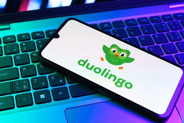 Prag, Çek Cumhuriyeti - 09 02 2025: Diz üstü bilgisayardaki telefon renkli ışık Duolingo logosunu gösteriyor. Duolingo interaktif olarak dil öğrenmek için bir platformdur..
