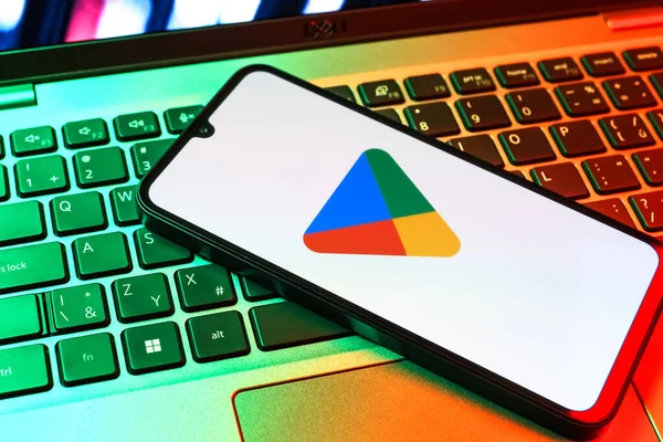 Prag, Çek Cumhuriyeti - 09 02 2025: Google Play logosunun renkli ışıklarla aydınlatıldığı dizüstü bilgisayardaki telefon. Google Play uygulamaları, oyunları ve dijital içeriği indirmek için bir platformdur.