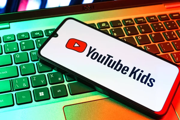 Prag, Çek Cumhuriyeti - 09 02 2025: Renkli ışık tarafından yakılan dizüstü bilgisayardaki telefon Youtube Kids logosunu gösteriyor. Youtube Kids çocuk dostu video içeriği için bir platformdur.
