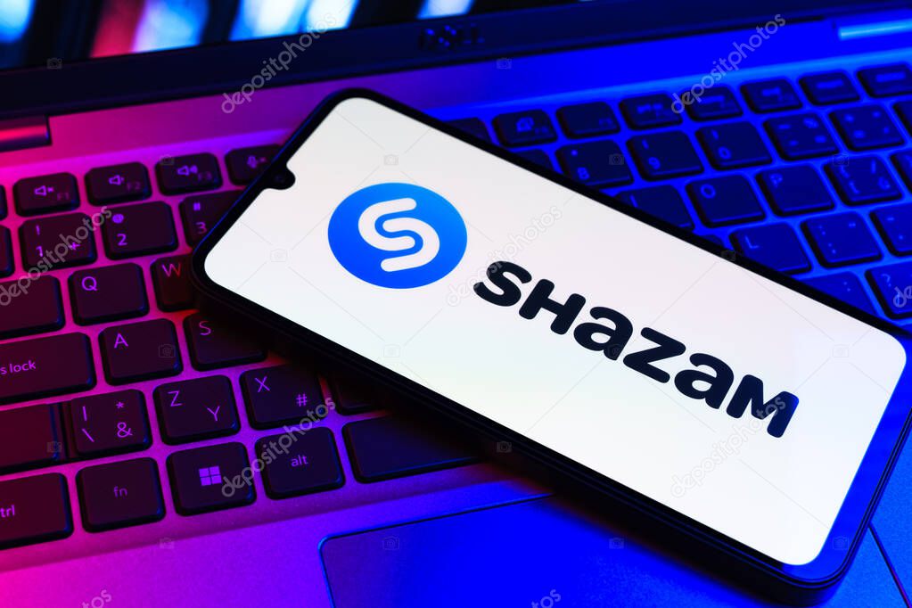Prague, Czechia - 09 02 2025: Phone on laptop keyboard lit by colored light shows Shazam logo. Shazam is an app for identifying songs and music tracks.