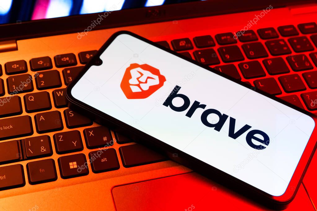 Prague, Czechia - 09 02 2025: Phone on laptop keyboard lit by colored light shows Brave logo. Brave is a web browser focused on privacy and speed.