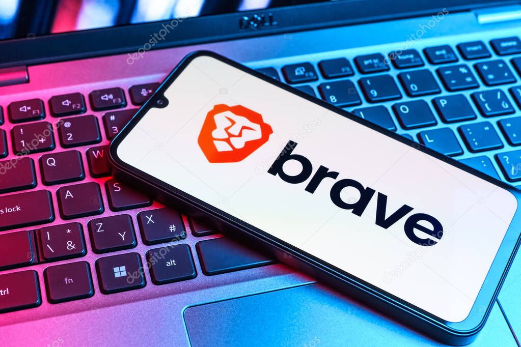 Prague, Czechia - 09 02 2025: Phone on laptop keyboard lit by colored light shows Brave logo. Brave is a web browser focused on privacy and speed.