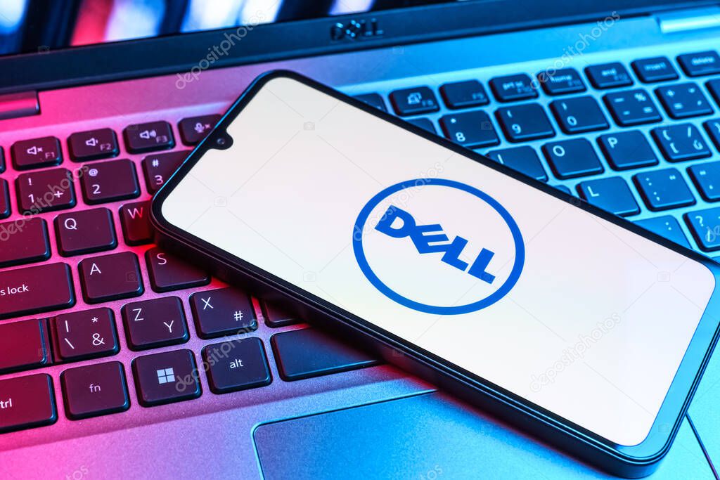 Prague, Czechia - 09 02 2025: Phone on laptop keyboard lit by colored light shows Dell logo. Dell is a technology company producing computers and IT solutions.