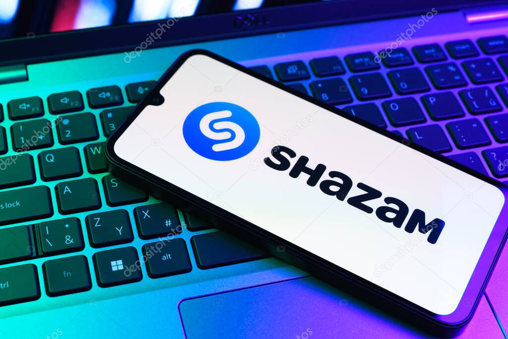 Prague, Czechia - 09 02 2025: Phone on laptop keyboard lit by colored light shows Shazam logo. Shazam is an app for identifying songs and music tracks.